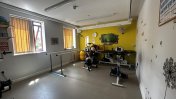 A physiotherapy room filled with physio equipment with a yellow back wall and yellow blinds