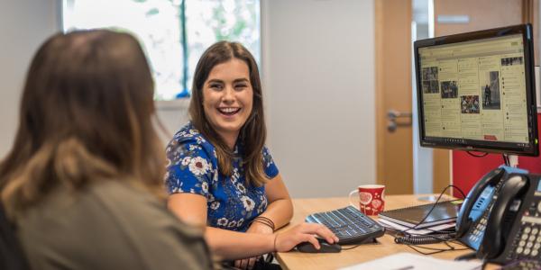 Woman smiling on a computer