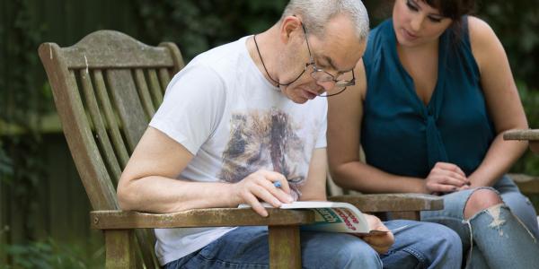 Two people reading on a bench