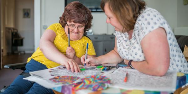 A carer does art and colouring in with a resident