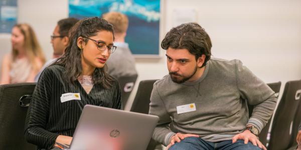 A woman and man looking at a laptop and chatting