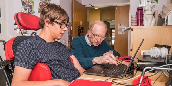 Rob, a volunteer, with Sam, a resident, in his bedroom at Lavender Fields