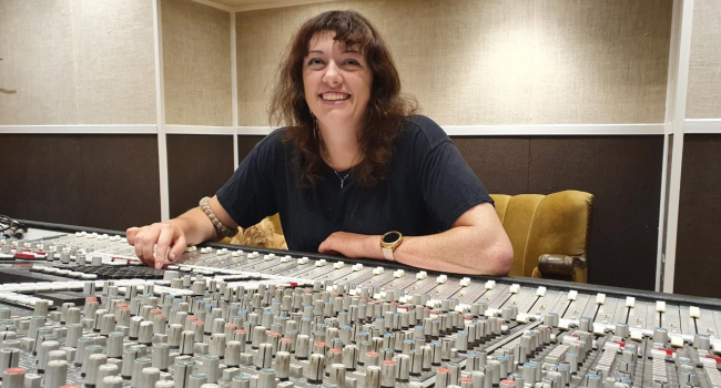Grace smiling in front of a mixing deck