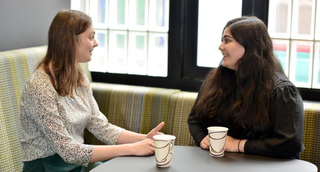Two Change 100 interns chatting over coffee during their internship at Overbury