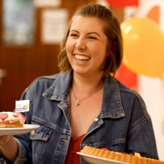 A woman holding two cakes