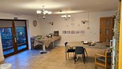 A beige tiled floor kitchen and dining area with brown windowed patio doors and table and chairs