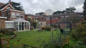 The back of the house with a conservatory backing onto a green lawn