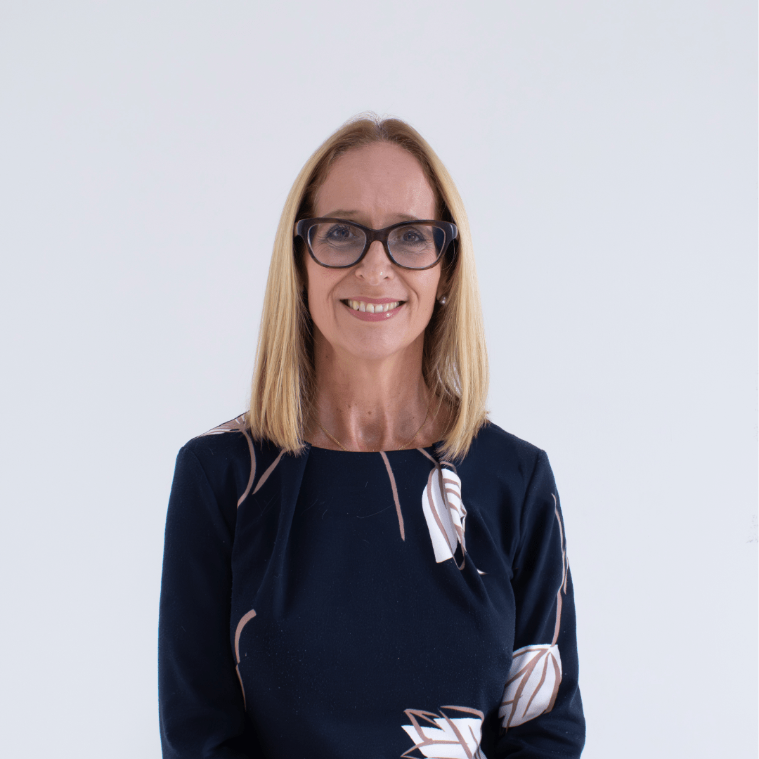 A caucasian female with long blond hair wearing black rimmed glasses and wearing a black top