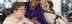 Two caucasian female residents in wheelchairs either side of a female african care worker wearing a purple Leonard Cheshire branded t shirt smiling 