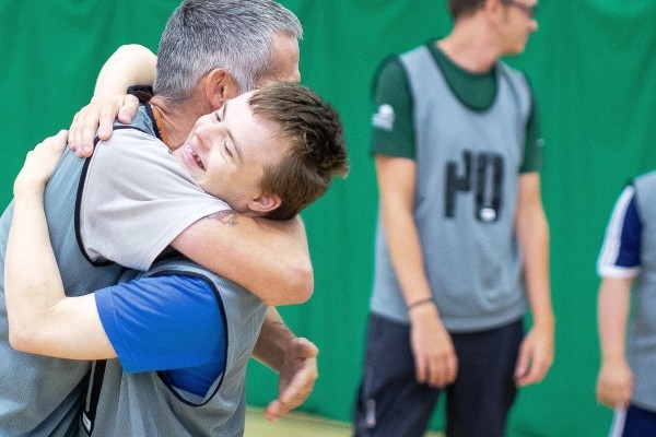 Two people hug while celebrating at a sporting event