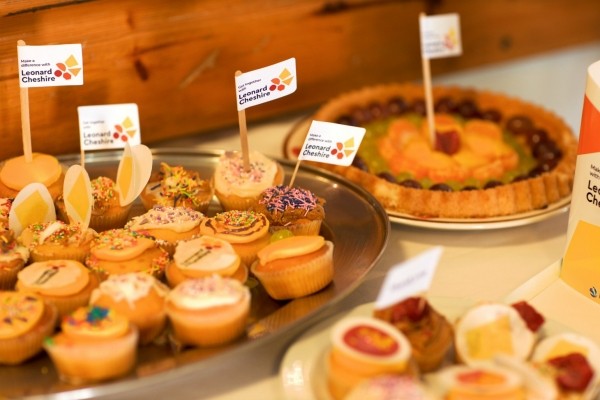 A tray of cupcakes with Leonard Cheshire flags in the cakes