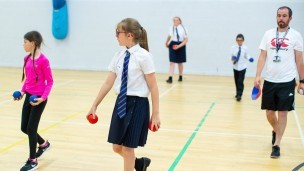 A group of children in school uniform in a sports hall