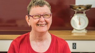 Sue, a service user, enjoys a sandwich she has prepared