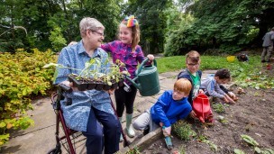 A young girl helps an older woman with the gardening