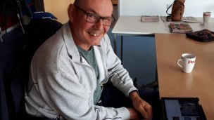 A man sitting at a table in front of an iPad