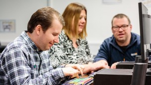 Karina. Gareth, and Steve using computers at the STARS Community Centre
