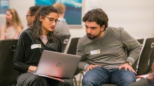 A woman and man looking at a laptop and chatting