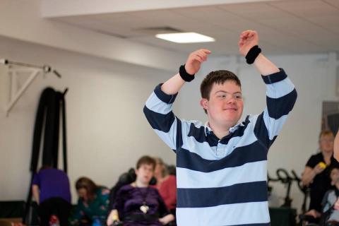 Young adult with his arms in the air dancing