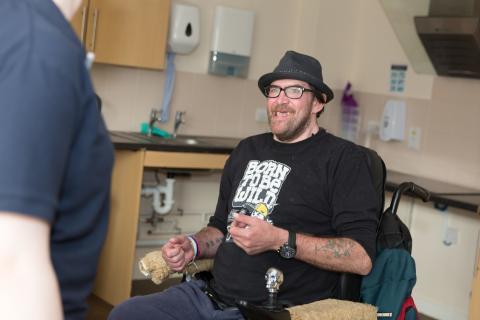 Resident in kitchen at Ty Cwm