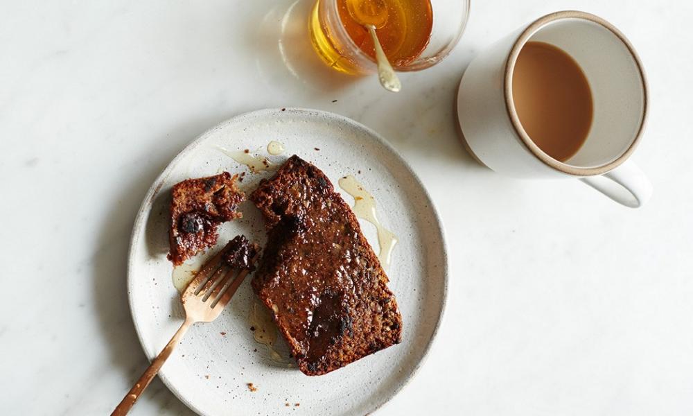 A Banana bread presented on a table with a cup of tea