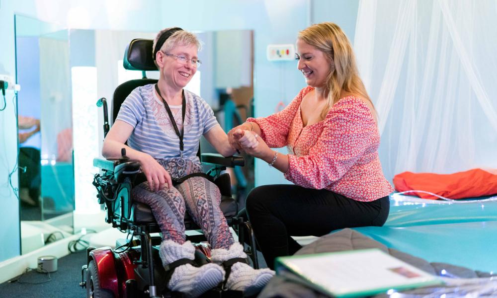A carer supports one of our residents with muscle movement in her wrist