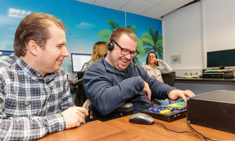 Two men sitting in front of a computer