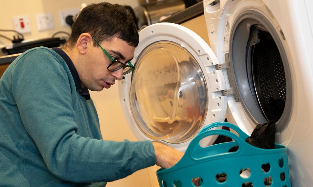 Jonathan using a washing machine at Eden Square