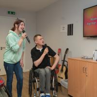 Courtney, a day centre user, with Grzegorz, a volunteer singing karaoke 