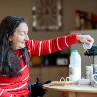 Female wheelchair user making a cup of tea