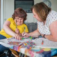 A carer does art and colouring in with a resident