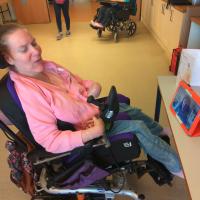 A woman in her wheelchair sitting in front of her iPad