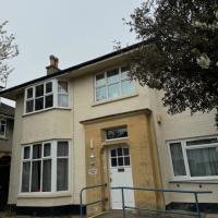 Exterior view of house with a white front door with window and a accessible ramp leading up to it