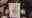 Zoey a caucasian female resident with long brown hair and tinted glasses wearing a black fleece holding up a drawing of Bonnie the dog with the words '10 years of love Bonnie' 