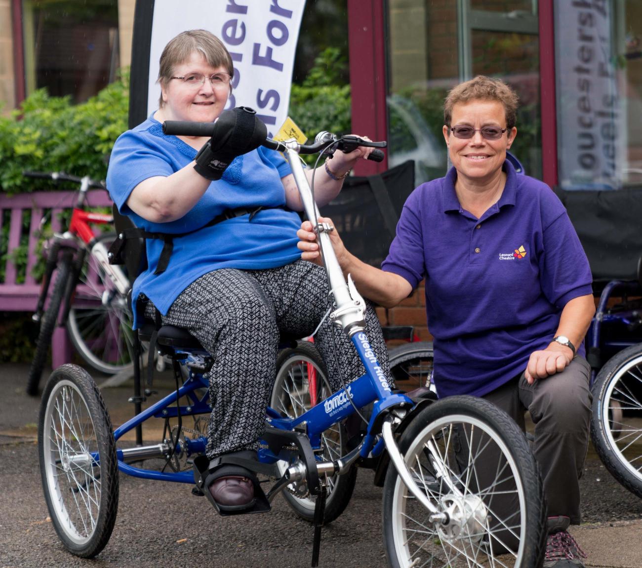A Gloucestershire House resident on an adapted bike with MaryClare next to her