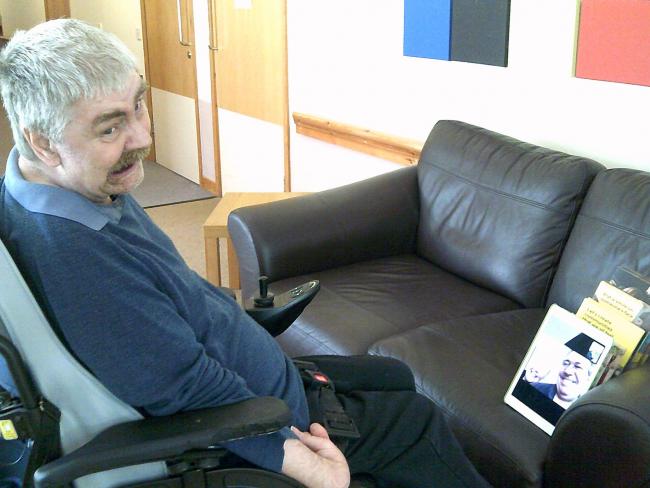 A man in his wheelchair in front of an iPad with skype on