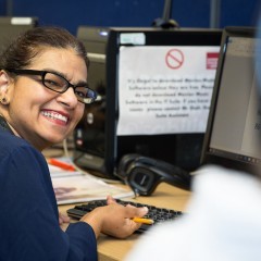A woman works at a computer