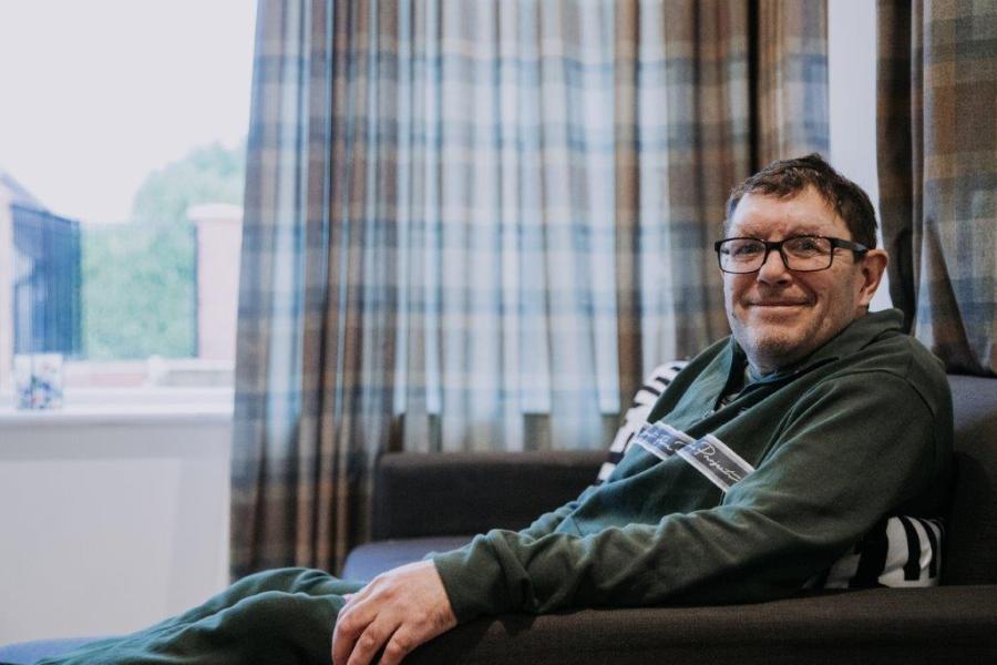 Scott sitting on his sofa