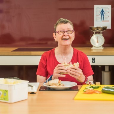 Sue, a visitor to our day centre in South London, enjoys a sandwich that she has prepared