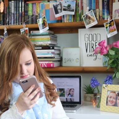 Emily Davison holding her phone in her bedroom