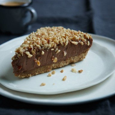A Nutella Cheesecake sits on a white plate on a table