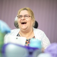 A woman wearing glasses laughs