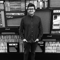 Our Campaigner poses in front of a wall of music related items