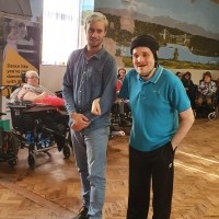 Two men, in a hall smiling