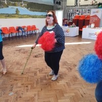 A woman with a walking cane and a pom pom