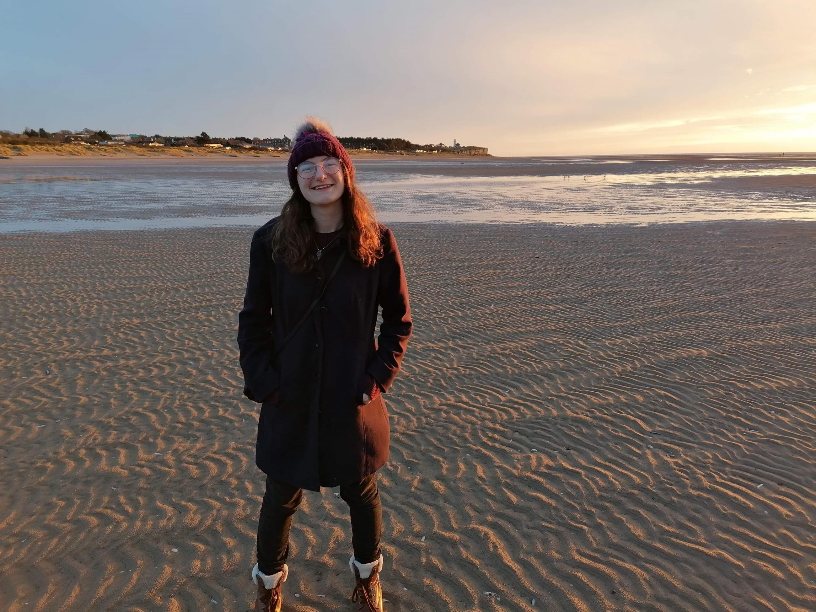 Ray standing on a beach smiling